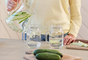 Glass of mineralised drinking water with calcium and magnesium icons (Ca, Mg) overlaid